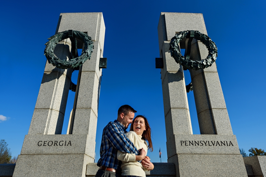 An engaged couple hug in between their home states at the WWII Memorial in DC for their engagement session.